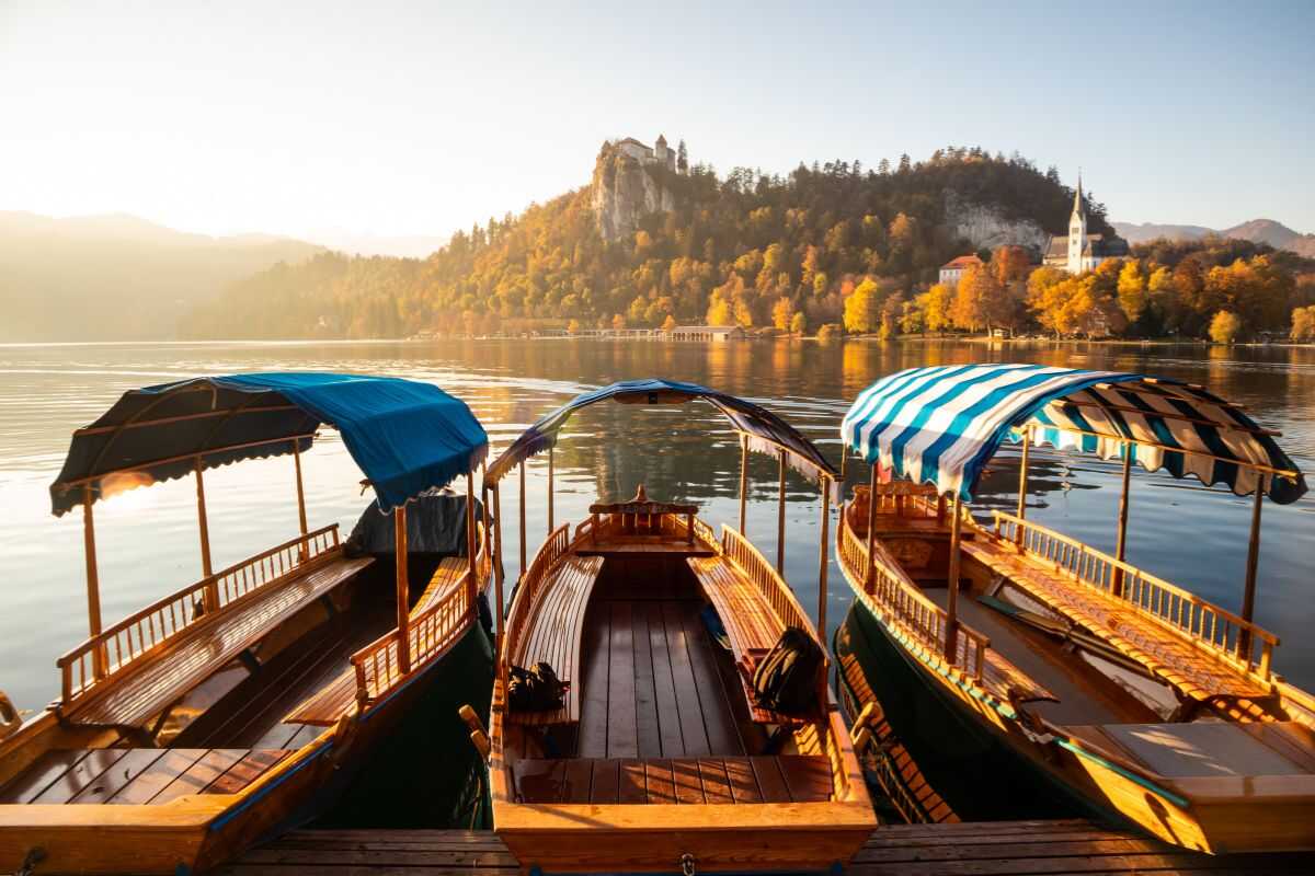 Traveler in a wooden boat on Lake Bled, Slovenia, experiencing car-free, eco-friendly travel in Europe’s greenest country.