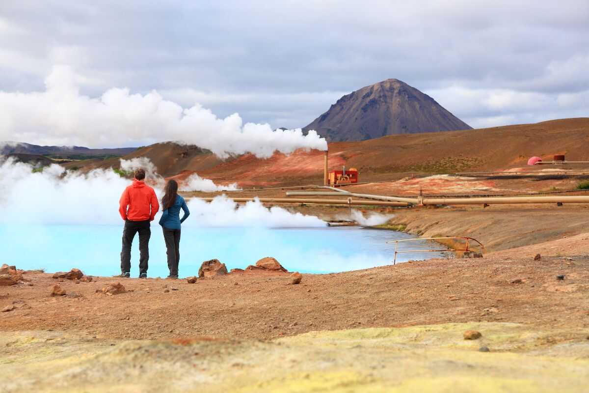 Traveler enjoying a geothermal hot spring in Iceland, powered by renewable energy and promoting eco-friendly travel.