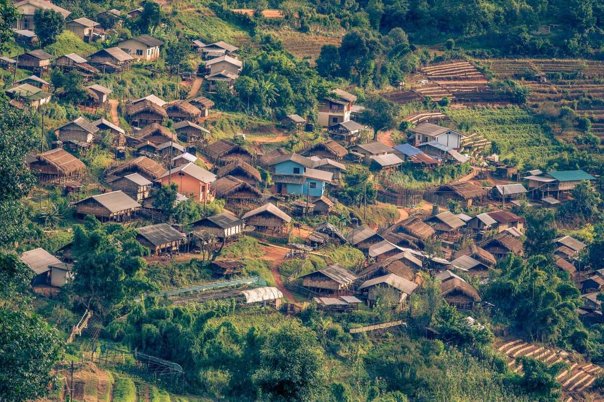 Tourists trekking in Northern Thailand visiting a traditional hill tribe village