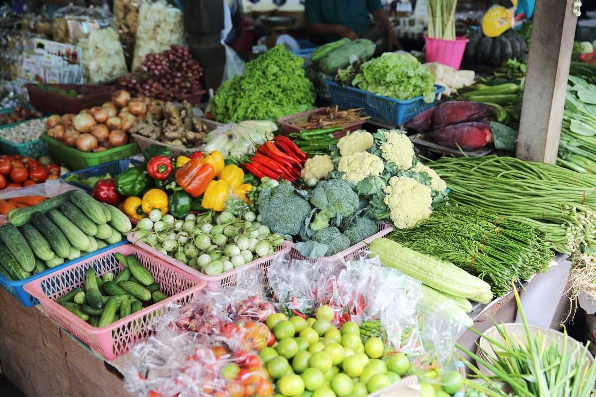 Colorful produce and spices at a Thai fresh market — limes, chili, lemongrass, galangal, etc.