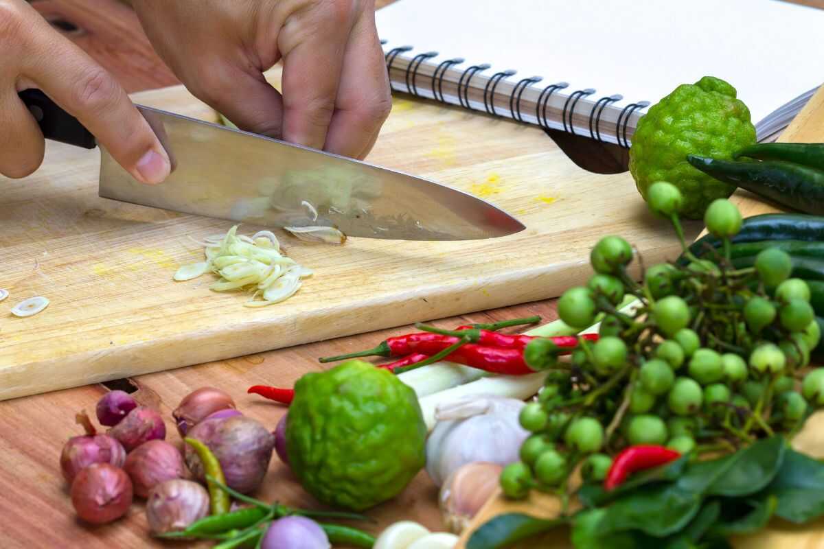 Thai cooking instructor teaching students how to grind fresh curry paste from scratch